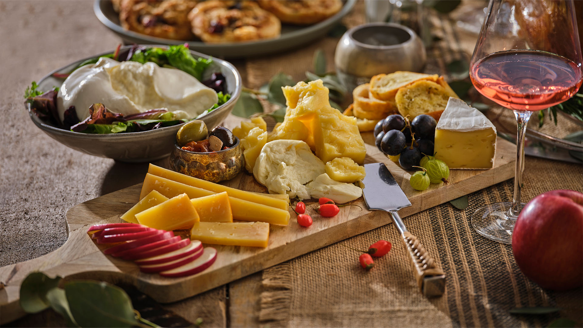 A wooden serving board featuring a wide variety of local, Ontario cheeses.